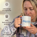 Frau trinkt aus einer bedruckten Tasse mit Hundeschul-Logo – spülmaschinengeeignet, Druck in Deutschland